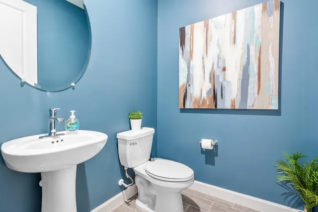 a bathroom with a toilet sink and mirror