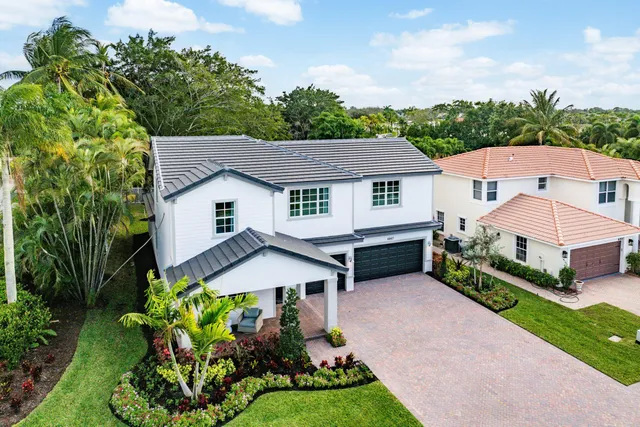 a aerial view of a house with a yard and potted plants