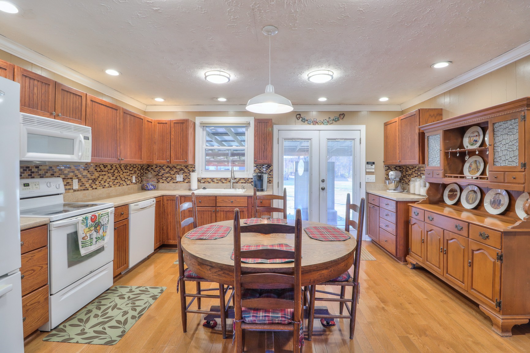1824 Logue Road Mount Juliet, TN 37122 - Photo 10 of 53 a kitchen with stainless steel appliances granite countertop a stove top oven a sink dishwasher a dining table and chairs with wooden floor