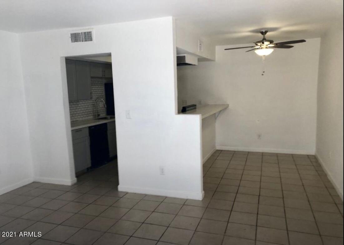 18202 North Cave Creek Road, Unit 117 Phoenix, AZ 85032 - Photo 2 of 6 a view of a livingroom with an empty space and a ceiling fan