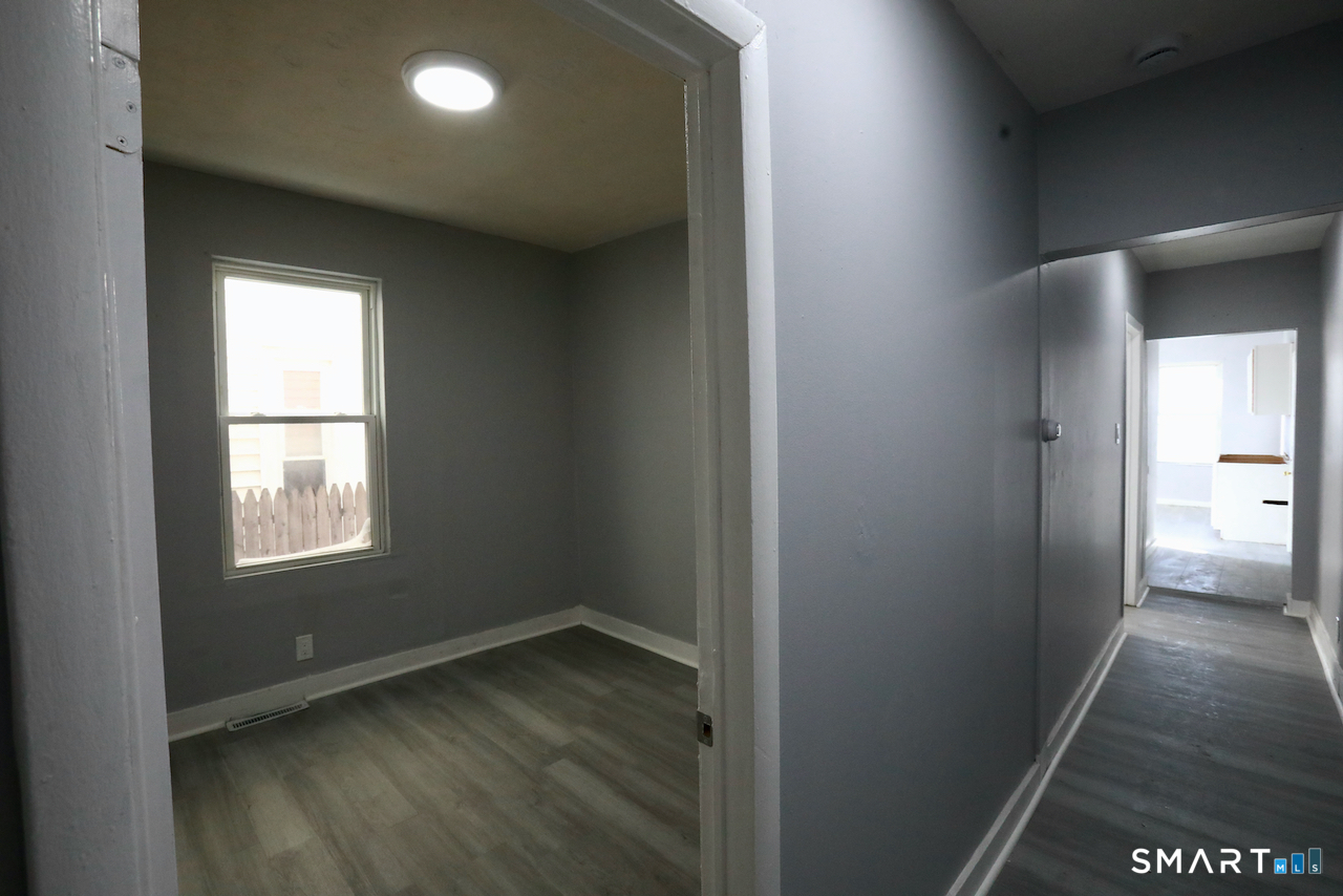 156 Poplar Street, Unit 1 New Haven, CT 06513 - Photo 13 of 31 an empty room with wooden floor and windows