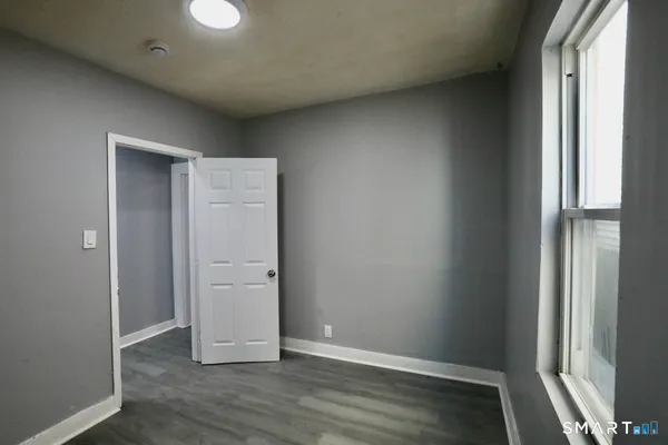 an empty room with wooden floor and closet