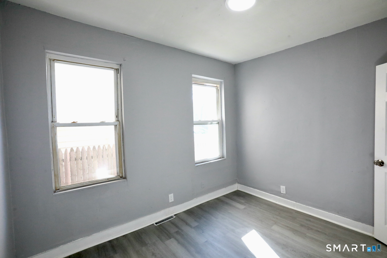 156 Poplar Street, Unit 1 New Haven, CT 06513 - Photo 18 of 31 an empty room with wooden floor and windows