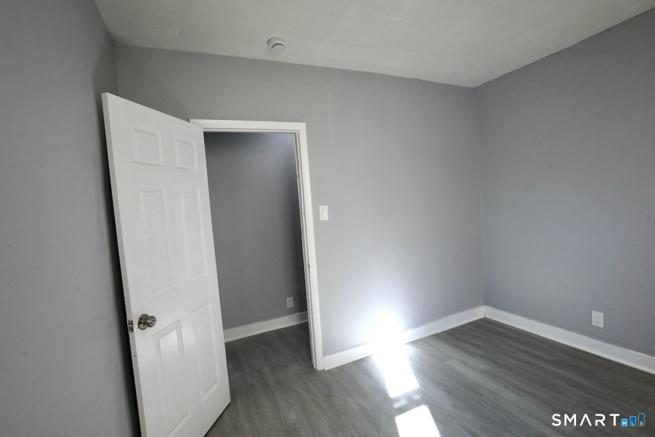 156 Poplar Street, Unit 1 New Haven, CT 06513 - Photo 22 of 31 an empty room with wooden floor and entrance