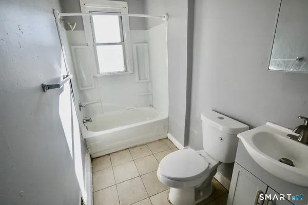 a white toilet sitting next to a bath tub