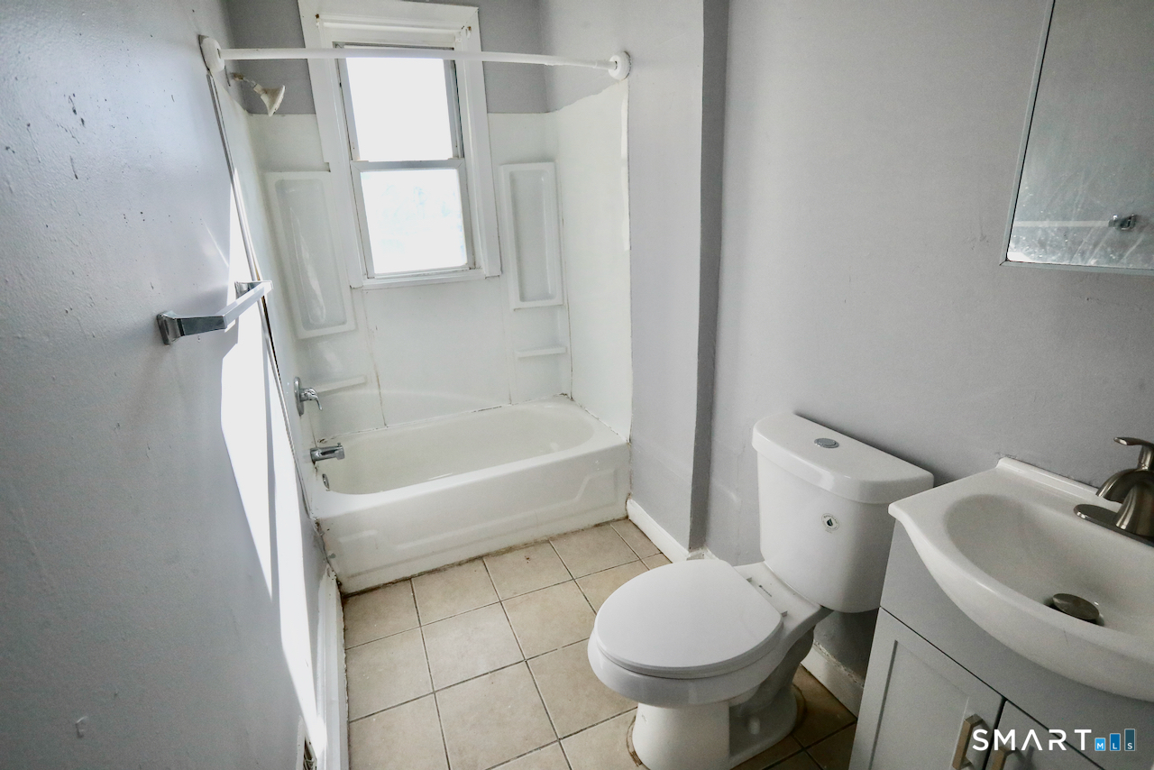 156 Poplar Street, Unit 1 New Haven, CT 06513 - Photo 24 of 31 a white toilet sitting next to a bath tub