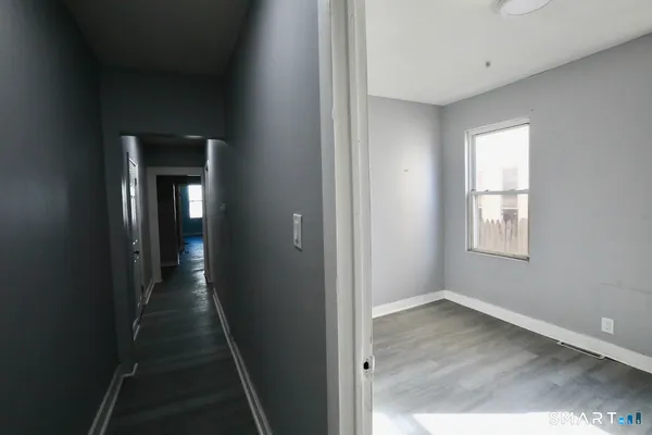 a view of a hallway with wooden floor and closet