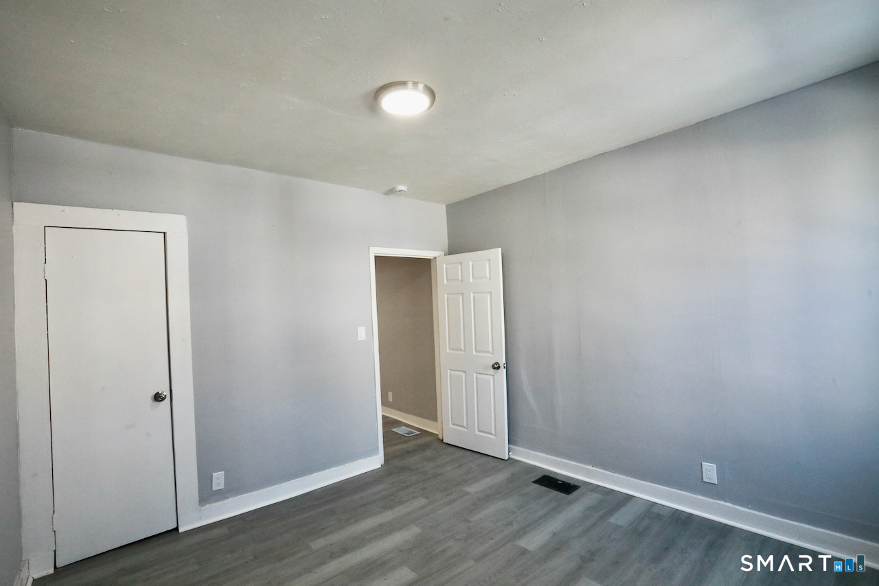 156 Poplar Street, Unit 1 New Haven, CT 06513 - Photo 4 of 31 an empty room with wooden floor and closet area