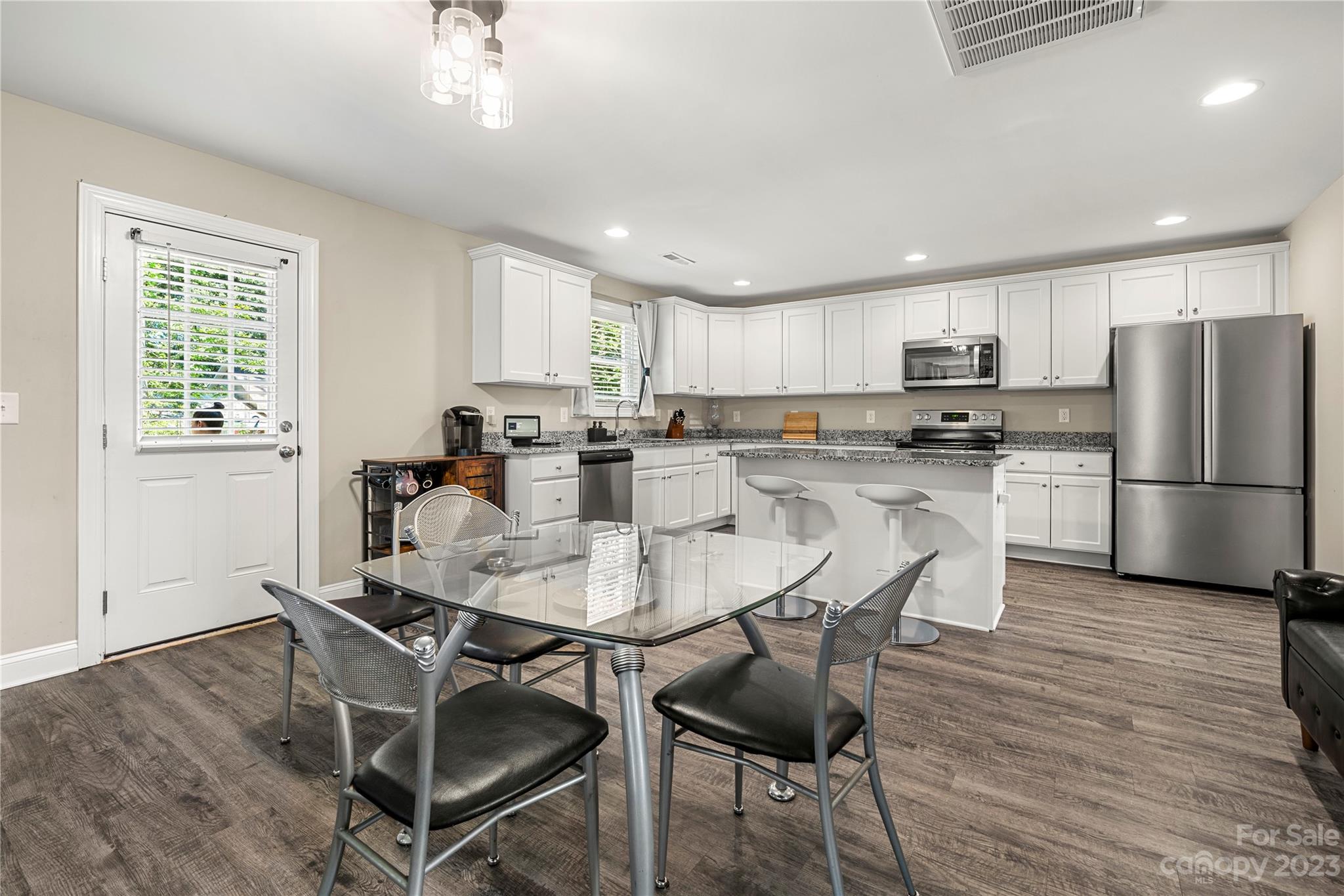 2000 Stirewalt Road China Grove, NC 28023 - Photo 11 of 43 a kitchen with stainless steel appliances granite countertop a dining table chairs refrigerator and microwave