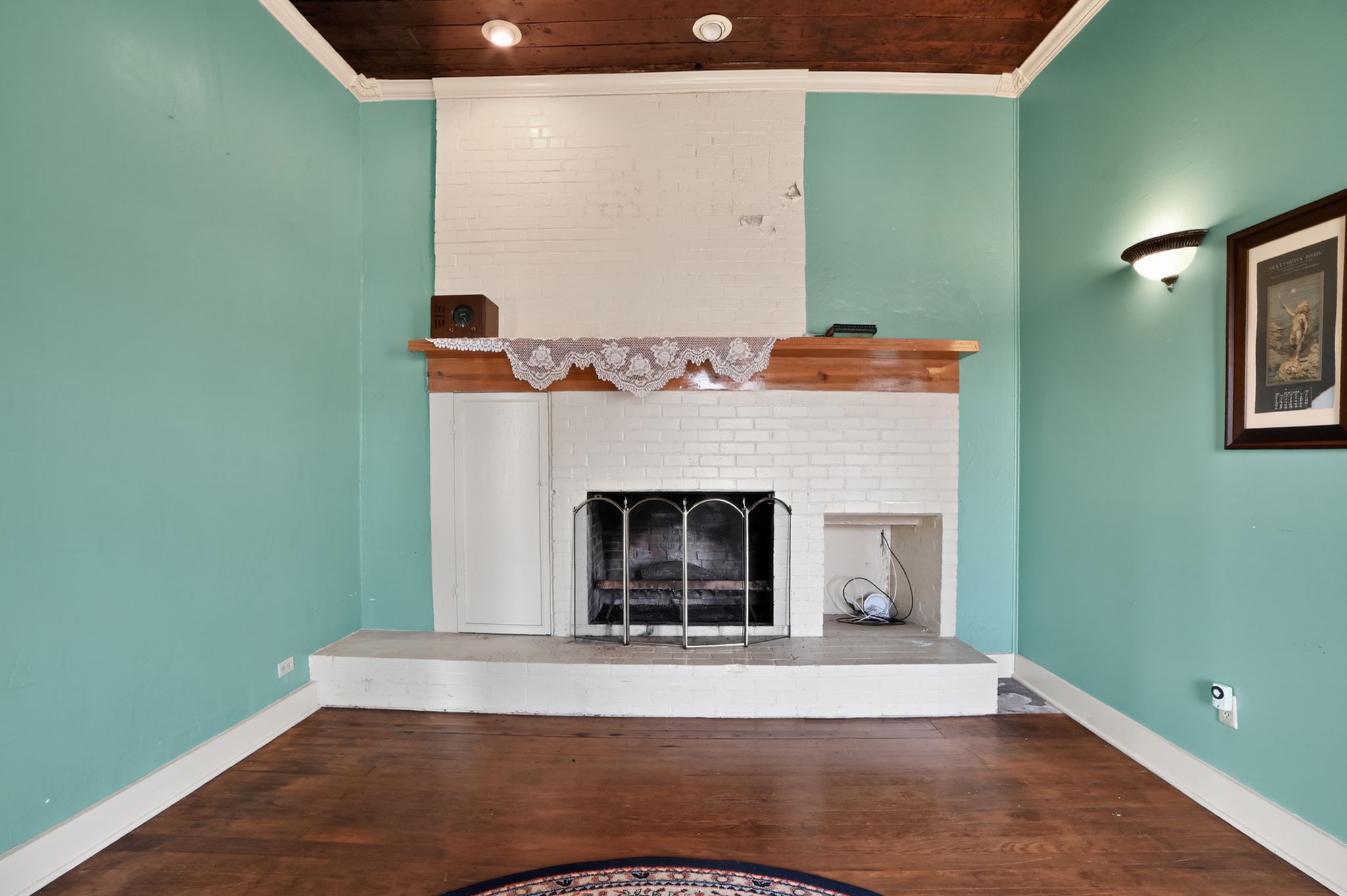 400 South Main Street Belton, TX 76513 - Photo 6 of 18 Unfurnished living room featuring dark wood-style flooring, a brick fireplace, and crown molding