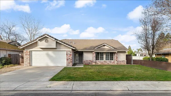 a front view of a house with a garden and trees