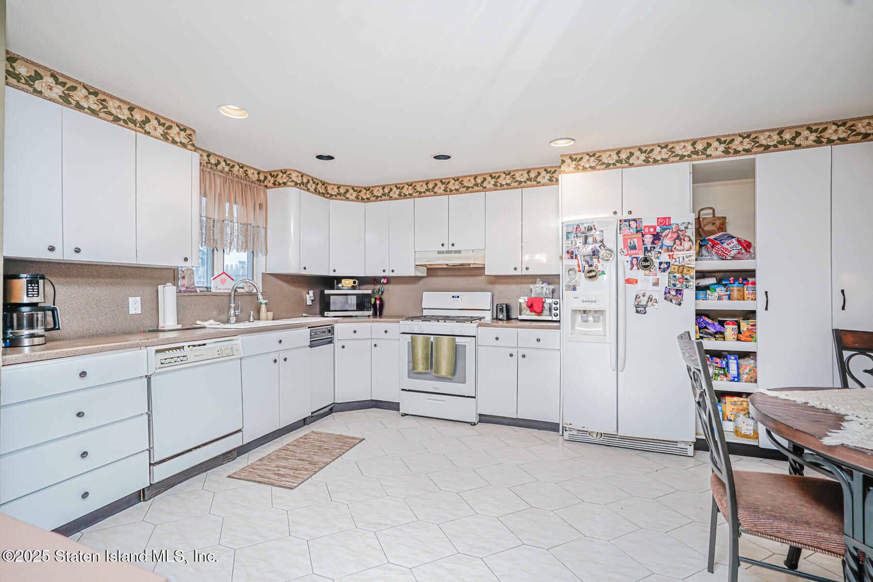 443 Ridgewood Avenue Staten Island, NY 10312 - Photo 7 of 26 a kitchen with white cabinets and white appliances
