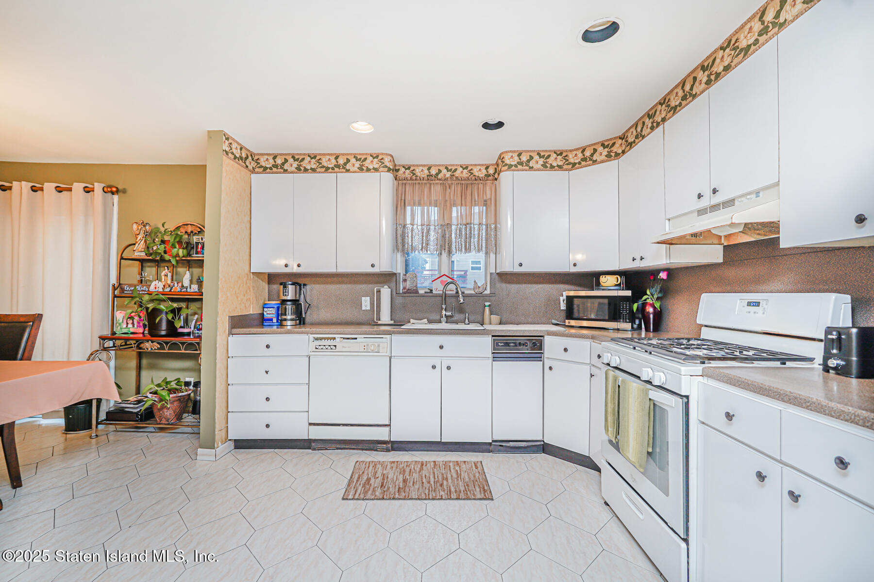 443 Ridgewood Avenue Staten Island, NY 10312 - Photo 9 of 26 a kitchen with granite countertop white cabinets and white appliances