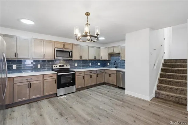 a kitchen with kitchen island granite countertop a sink cabinets and stainless steel appliances