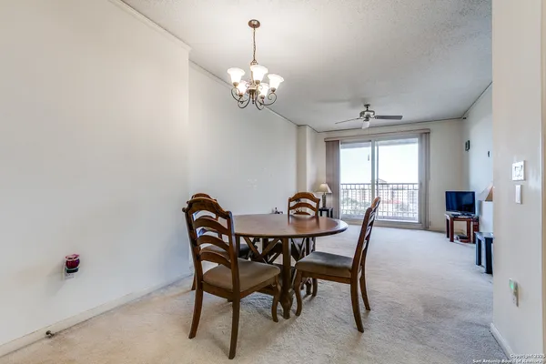a view of a dining room with furniture and a chandelier