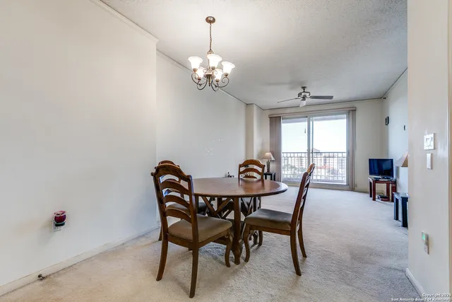 a view of a dining room with furniture and a chandelier