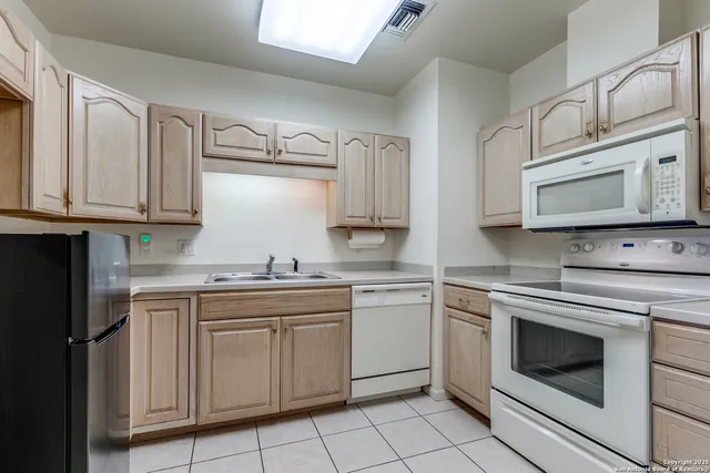 a kitchen with cabinets appliances and a sink