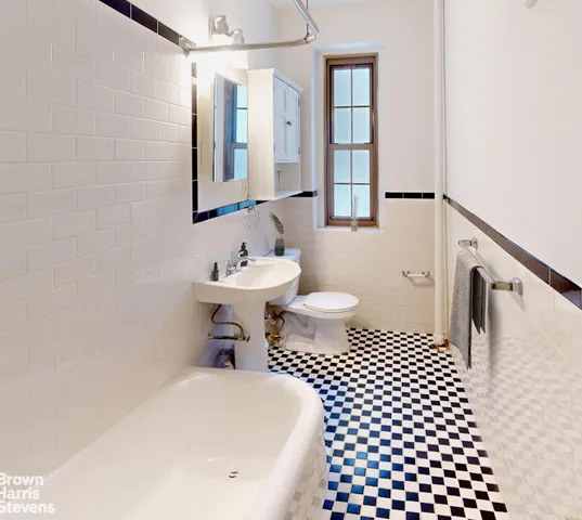 a bathroom with a white toilet sitting next to a window
