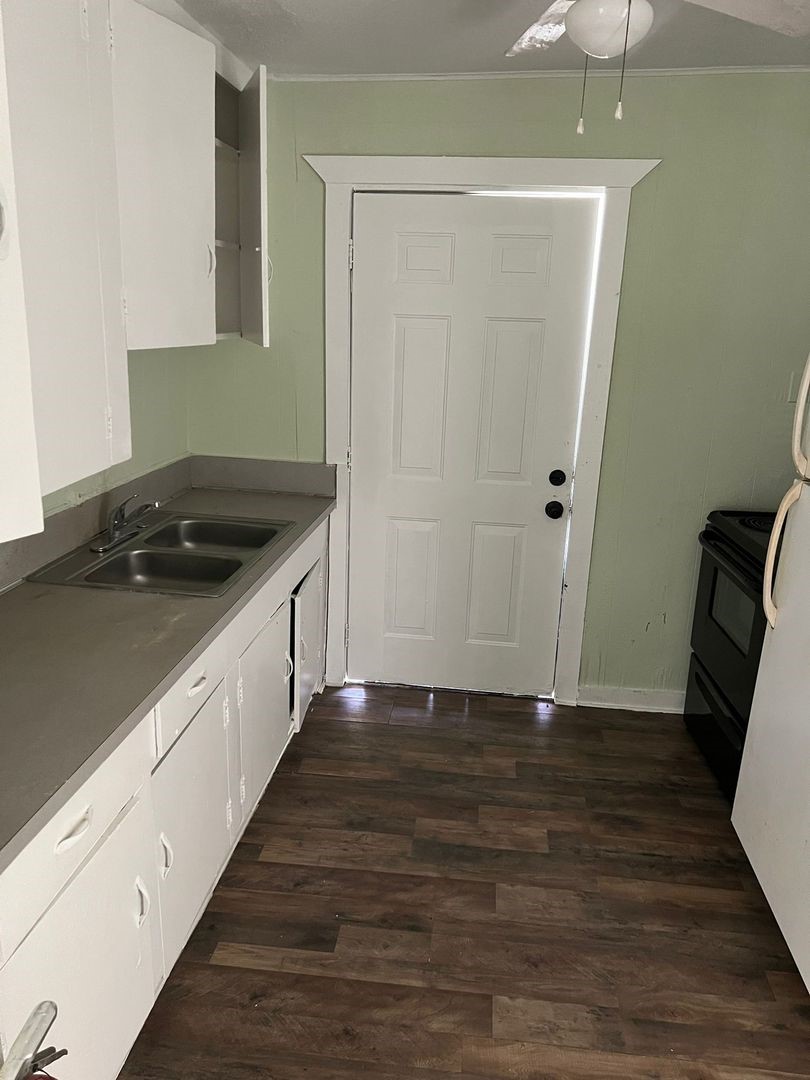 527 West 8th Street Freeport, TX 77541 - Photo 4 of 10 a kitchen with granite countertop a sink and a stove top oven