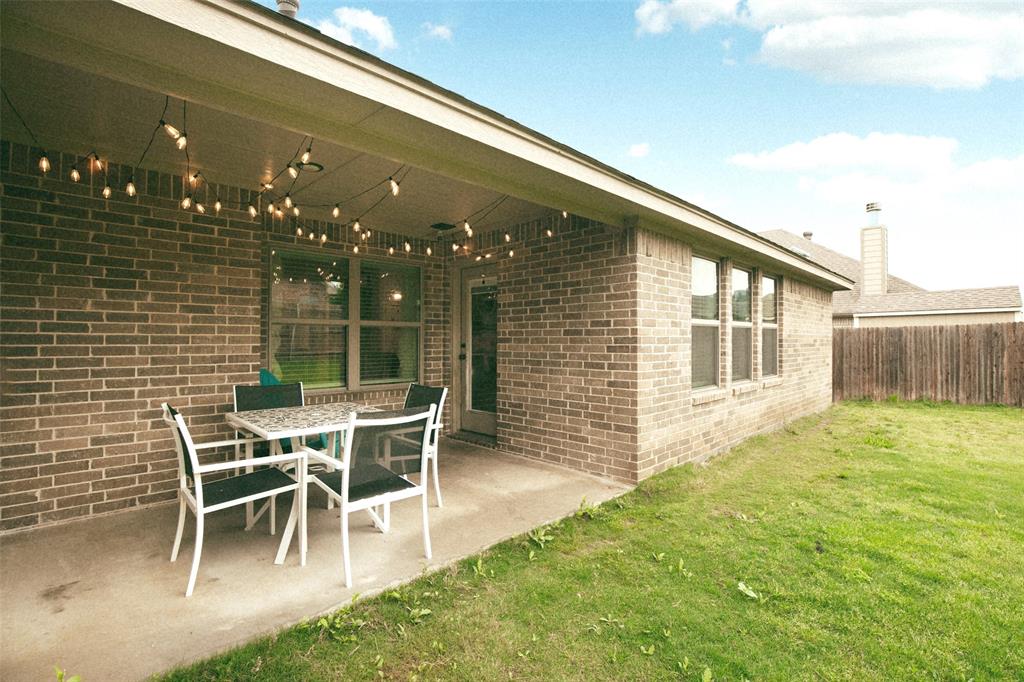 211 Rees Avenue Godley, TX 76044 - Photo 18 of 18 a patio with a table and chairs and potted plants