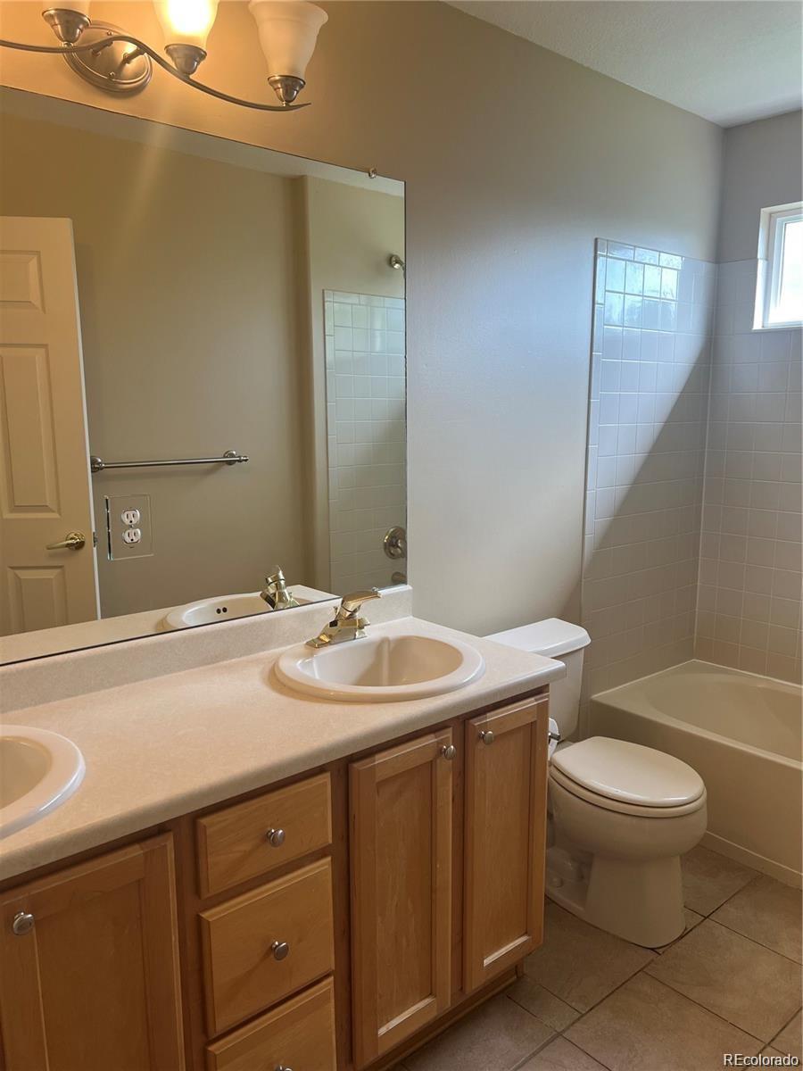 5353 Rhyolite Way Parker, CO 80134 - Photo 16 of 22 a bathroom with a sink a toilet and mirror