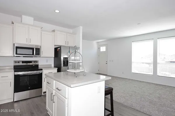 a kitchen with a sink a stove a microwave and a refrigerator