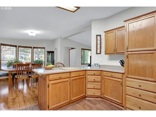 a living room with furniture a flat screen tv and kitchen view