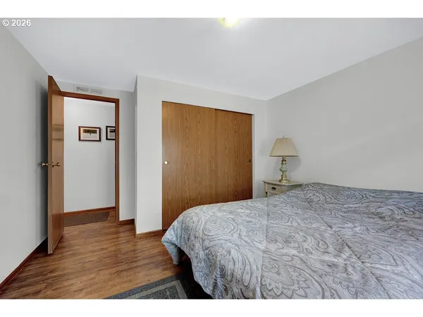 a bedroom with a bed a dresser and a flat screen tv