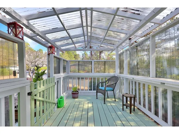 a view of an empty room with wooden floor and windows