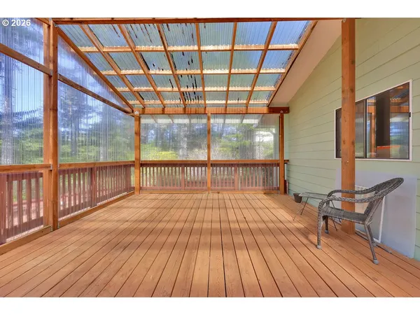 a balcony with wooden floor and outdoor seating