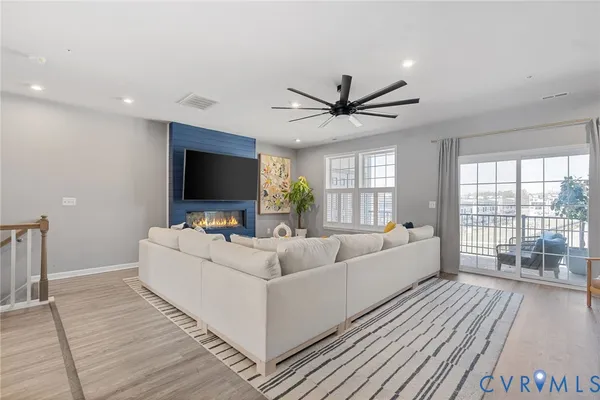 a living room with furniture a flat screen tv and a fireplace