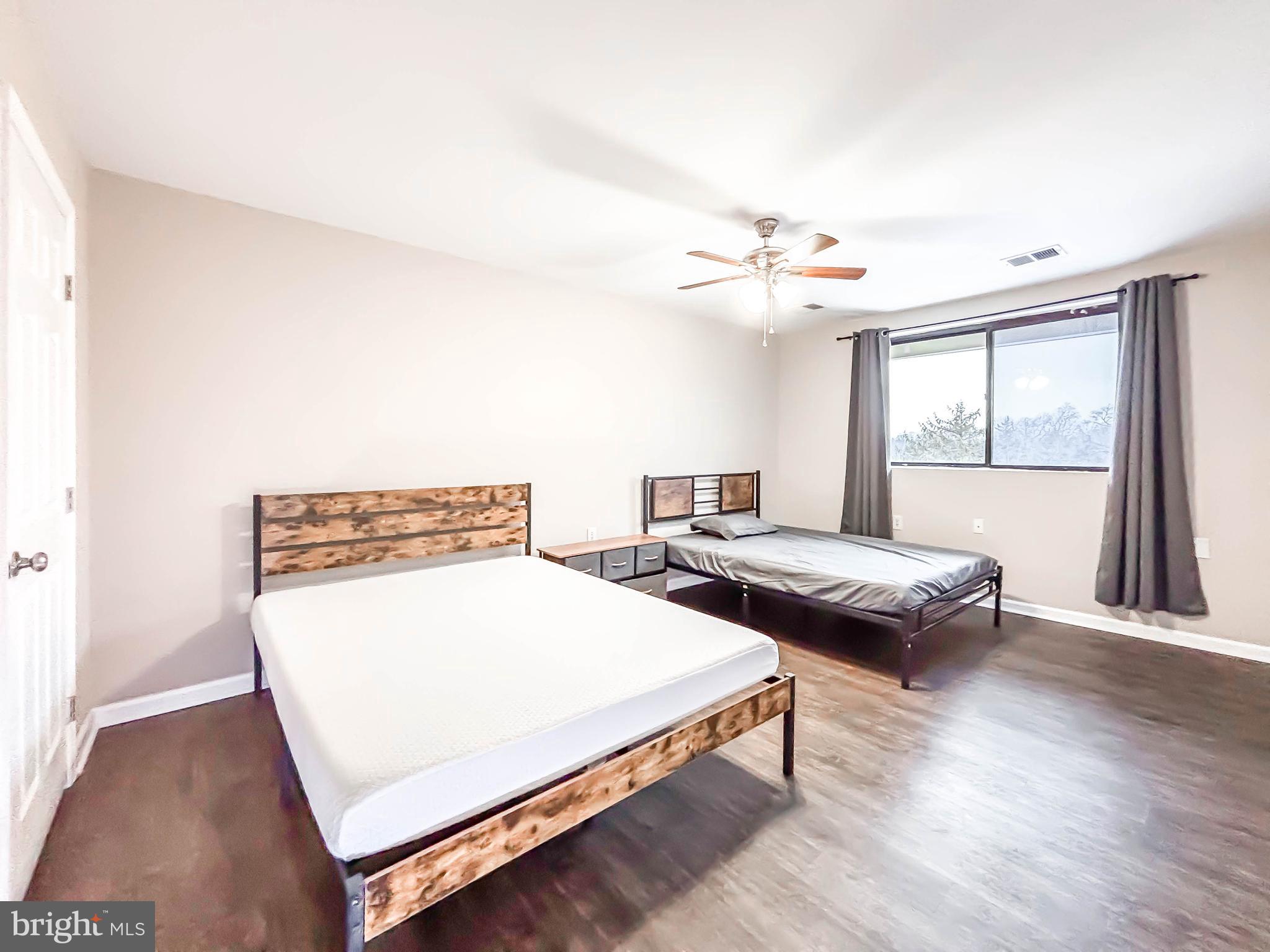 3924 Rolling Rd., Unit B11 Pikesville, MD 21208 - Photo 20 of 31 a bedroom with two beds and a chandelier