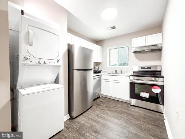 a kitchen with a refrigerator and a stove top oven