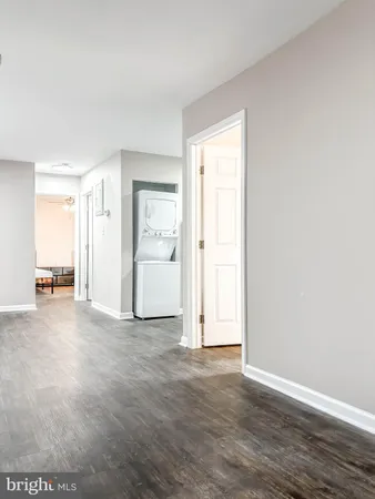 a view of a kitchen with refrigerator and wooden floor