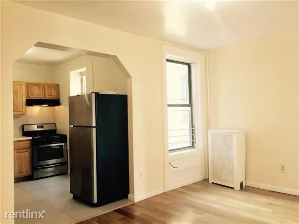 a view of a kitchen with wooden floor and refrigerator