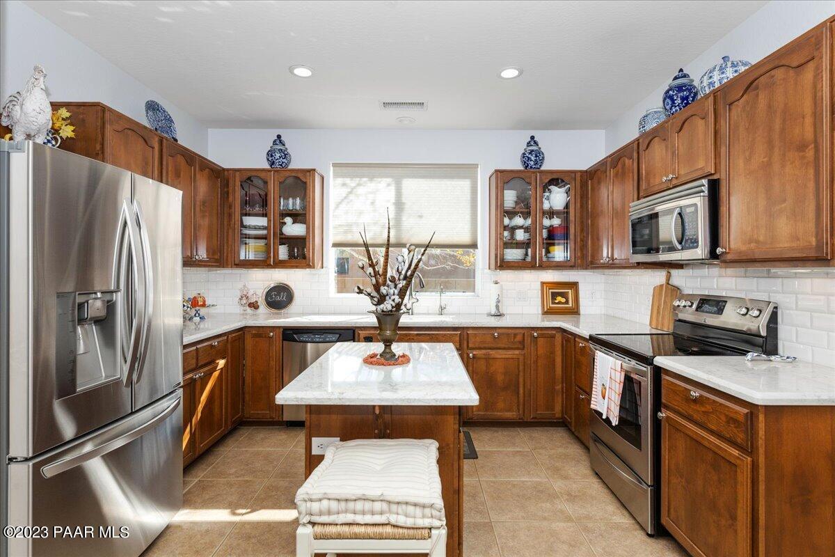 1908 North Fire Butte Way Prescott Valley, AZ 86314 - Photo 12 of 52 a kitchen with stainless steel appliances granite countertop a refrigerator a stove a sink a microwave and cabinets