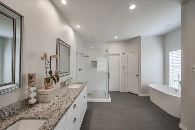 a spacious bathroom with a granite countertop sink mirror and a shower