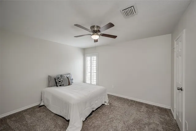 a bedroom with a bed and a ceiling fan