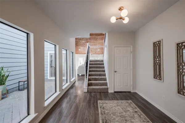 a view of a hallway with wooden floor and stairs