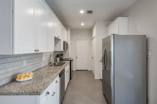 a kitchen with stainless steel appliances granite countertop a refrigerator and a sink