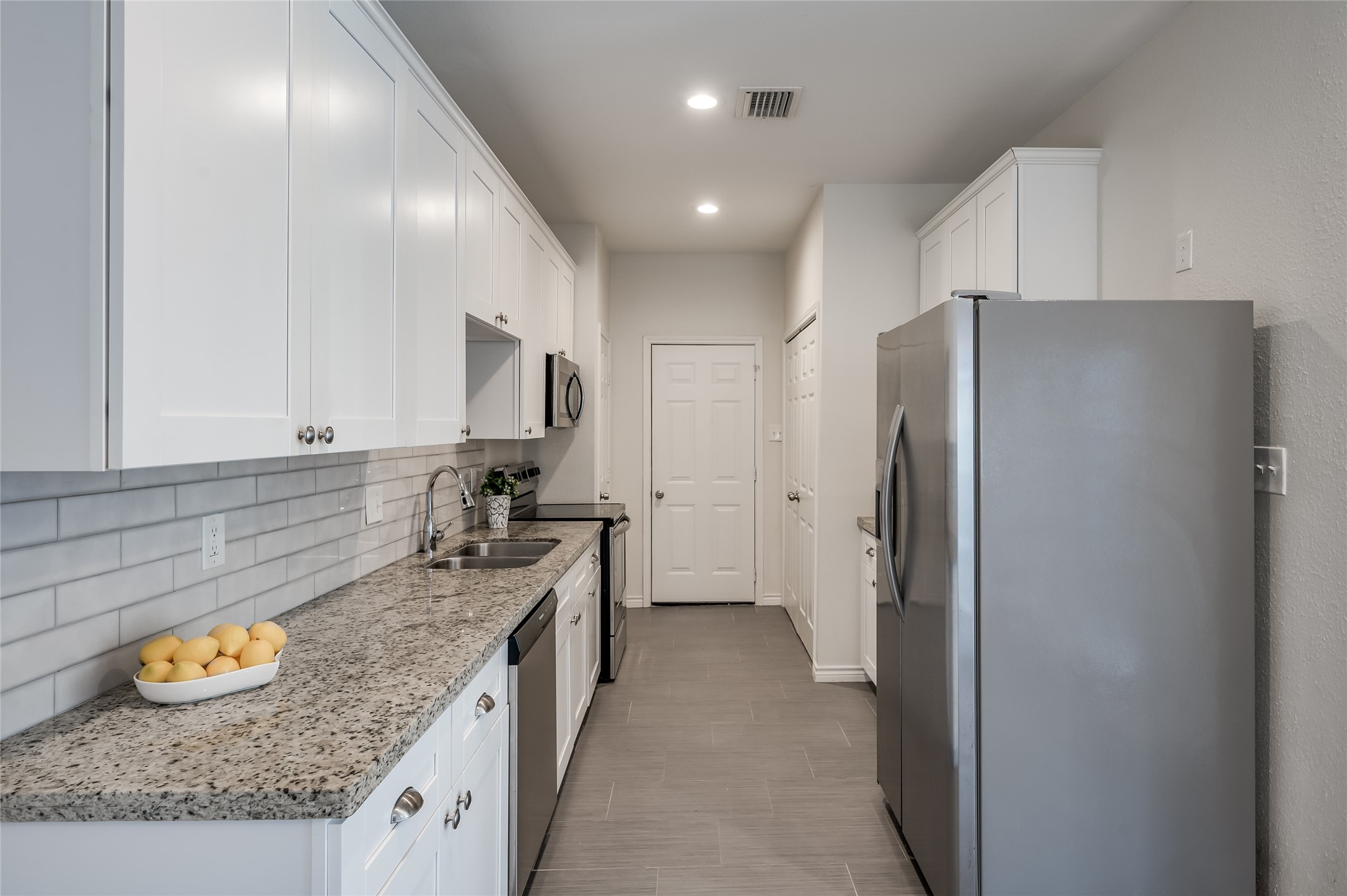 387 Rancho Bauer Drive Houston, TX 77079 - Photo 8 of 32 a kitchen with stainless steel appliances granite countertop a refrigerator and a sink