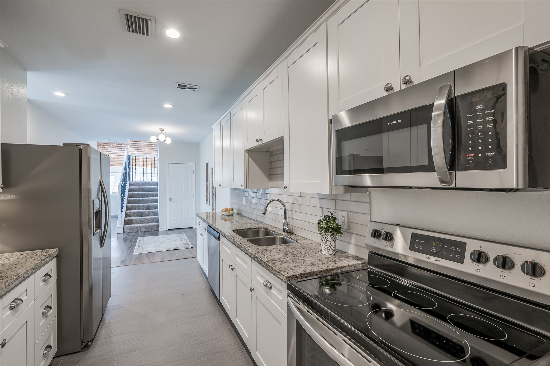 387 Rancho Bauer Drive Houston, TX 77079 - Photo 9 of 32 a kitchen with stainless steel appliances granite countertop a sink stove and refrigerator