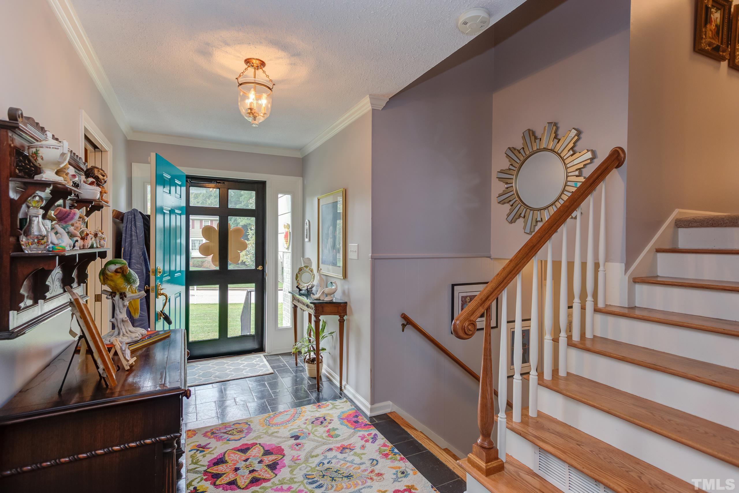 2509 Catalina Court Raleigh, NC 27607 - Photo 3 of 29 a view of a hallway with wooden floor and a chandelier