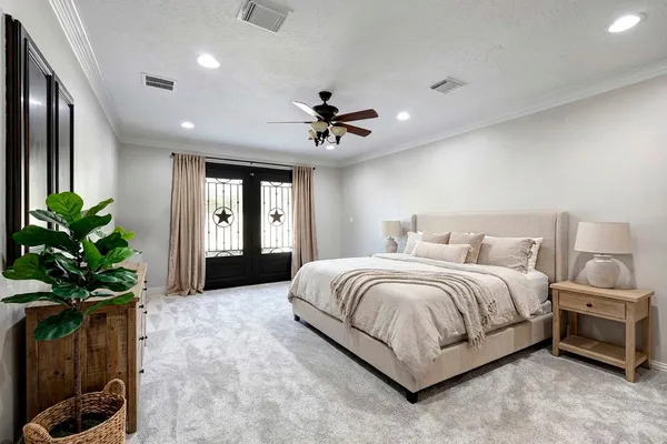 a spacious bedroom with a bed and a chandelier