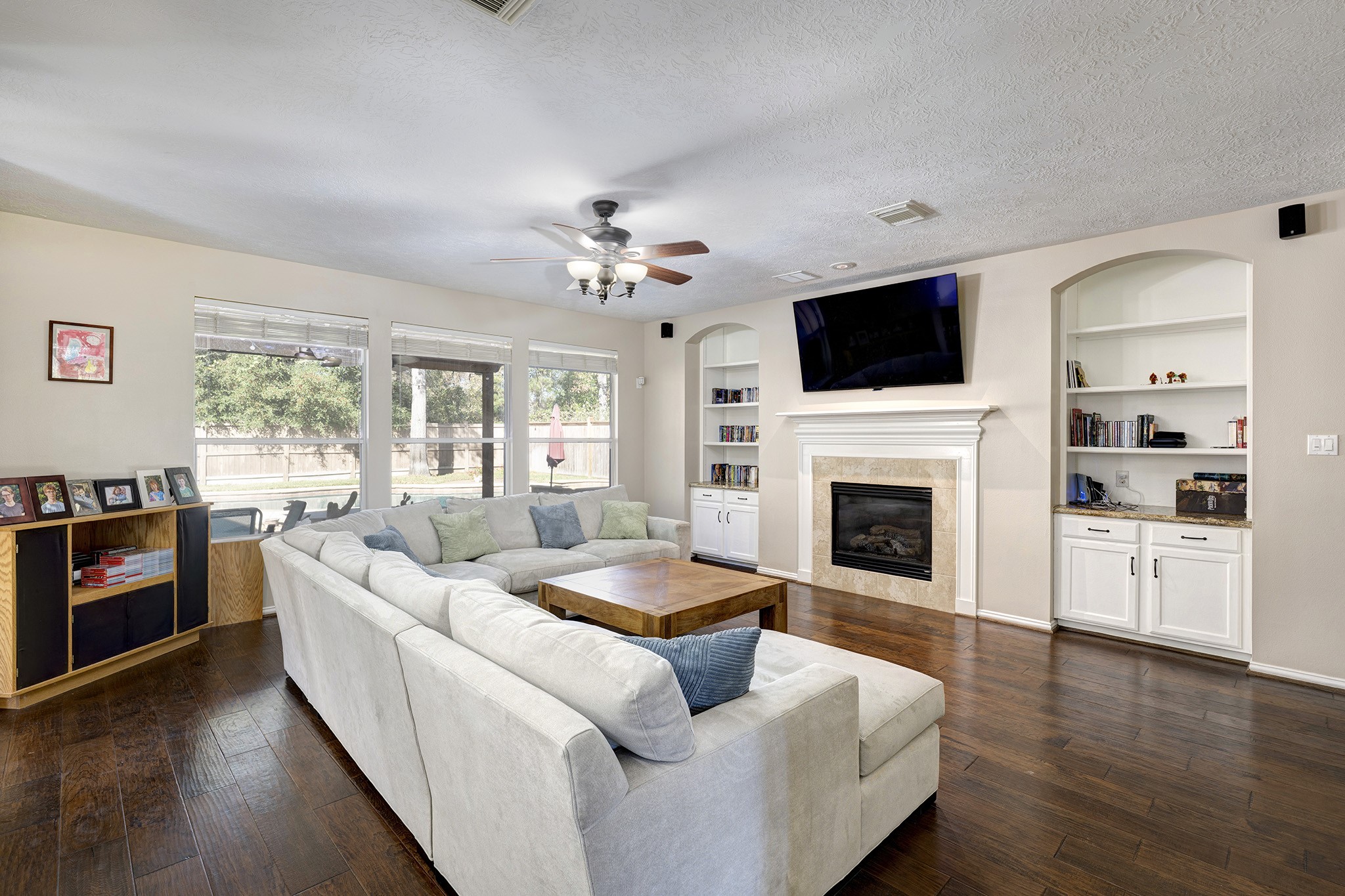2511 Bridgestone Park Lane Spring, TX 77386 - Photo 7 of 25 A gas log fireplace is flanked with built-in shelves and storage cabinets. Half bath and primary suite is to the right of the photo.