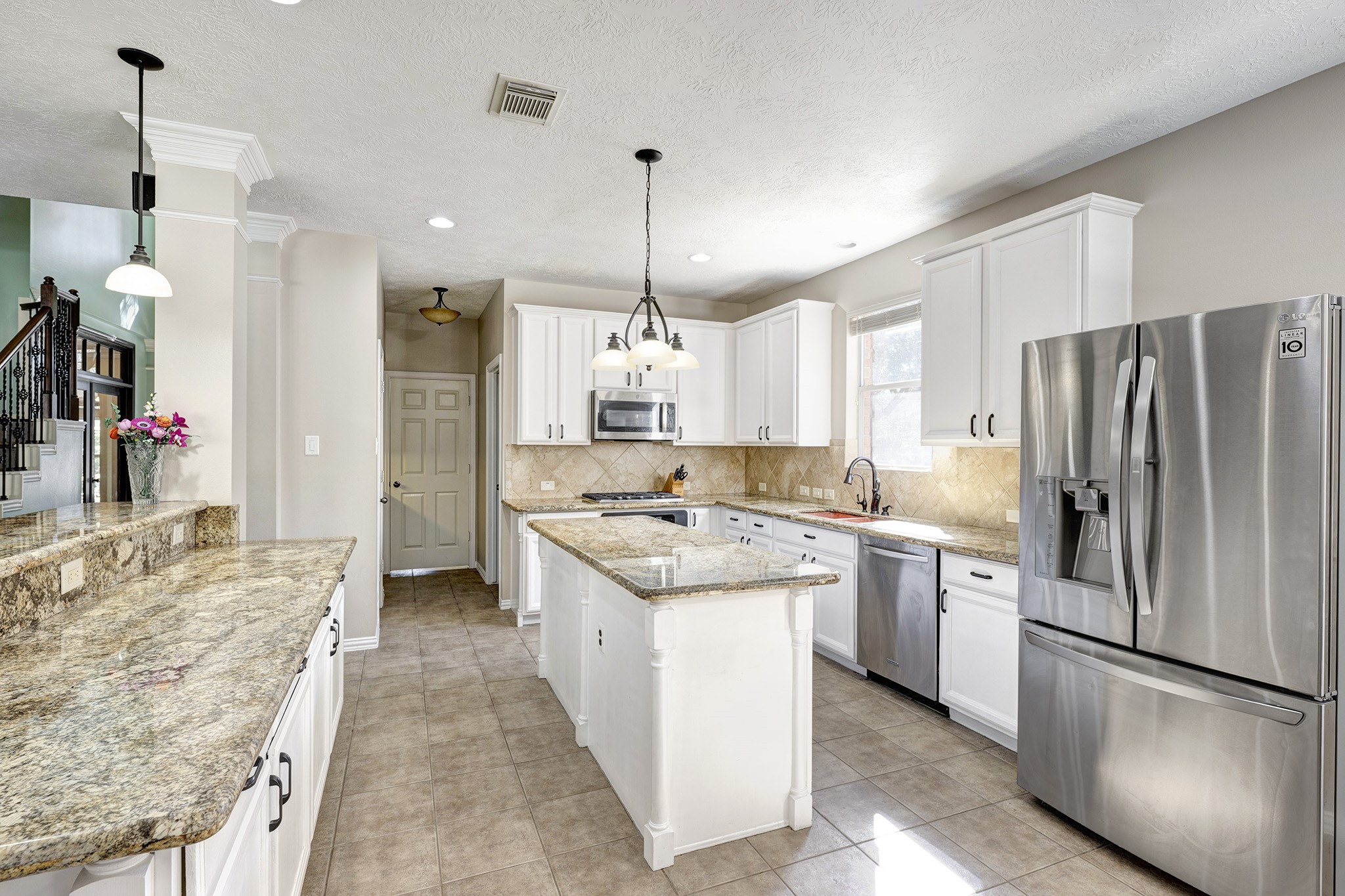 2511 Bridgestone Park Lane Spring, TX 77386 - Photo 9 of 25 The double island kitchen has gorgeous Rainforest granite countertops, a gas cooktop, and an abundance of storage.