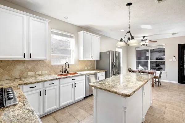 a kitchen with stainless steel appliances granite countertop stove top oven and refrigerator