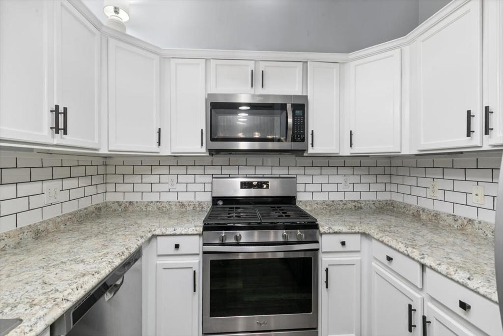 21 Hampshire Road, Unit 313 Methuen, MA 01844 - Photo 11 of 35 a kitchen with granite countertop white cabinets appliances a sink and a counter top