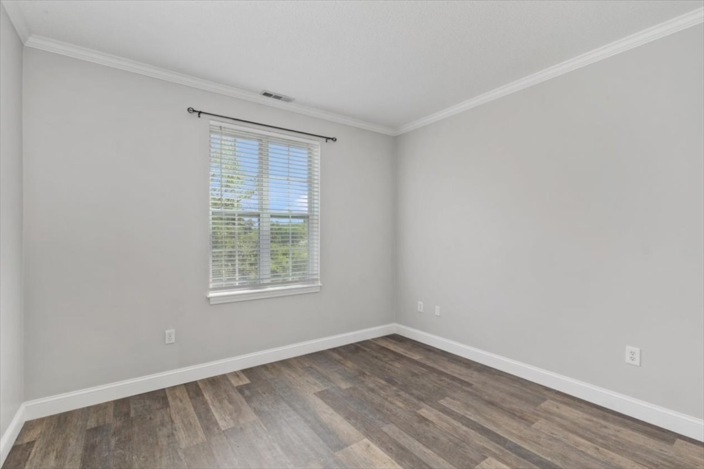 21 Hampshire Road, Unit 313 Methuen, MA 01844 - Photo 12 of 35 a view of an empty room with wooden floor and a window