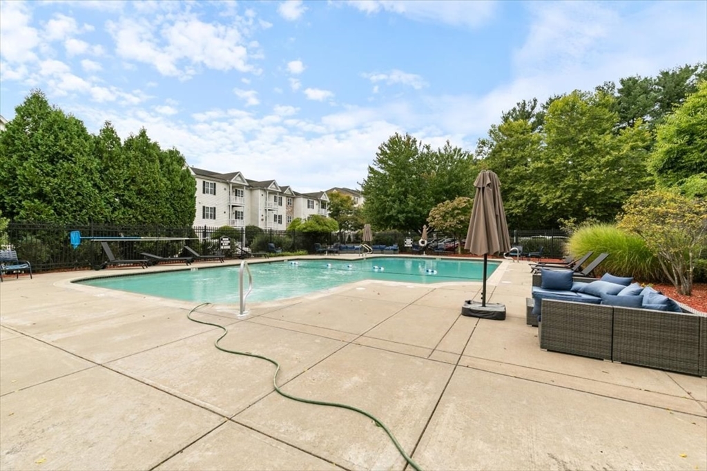 21 Hampshire Road, Unit 313 Methuen, MA 01844 - Photo 22 of 35 a view of swimming pool with seating area and trees in the background